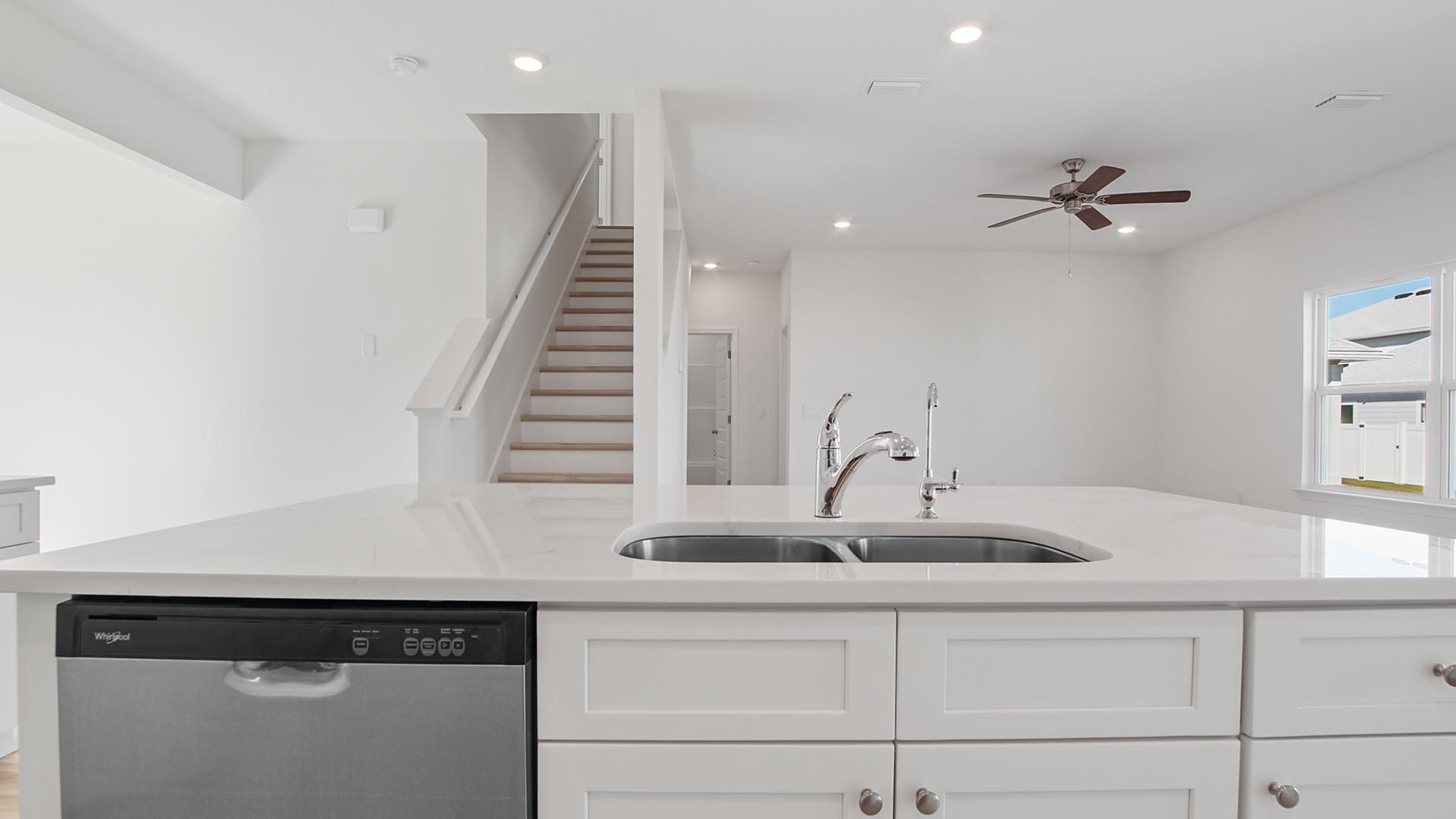 The kitchen island has a sink and dishwasher
