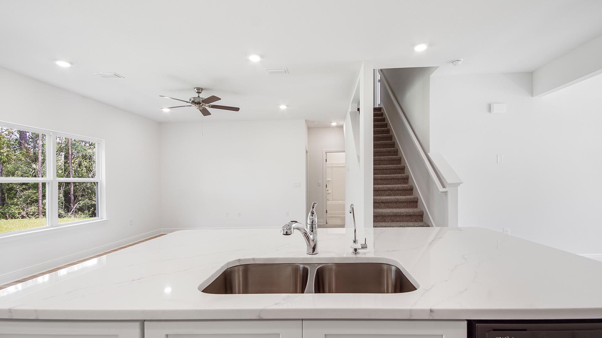 The kitchen island features a sink and stainless steel dishwasher
