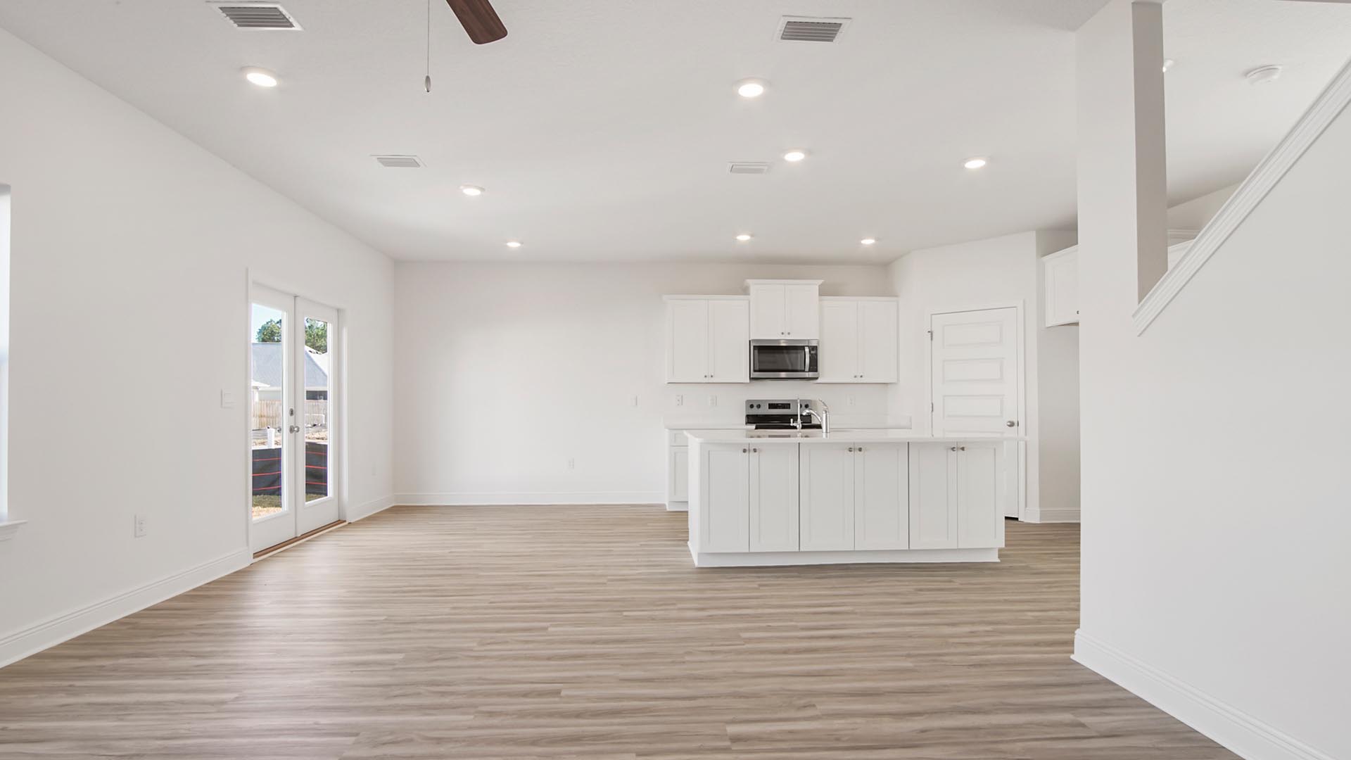 The large living area has EVP flooring and ceiling fan