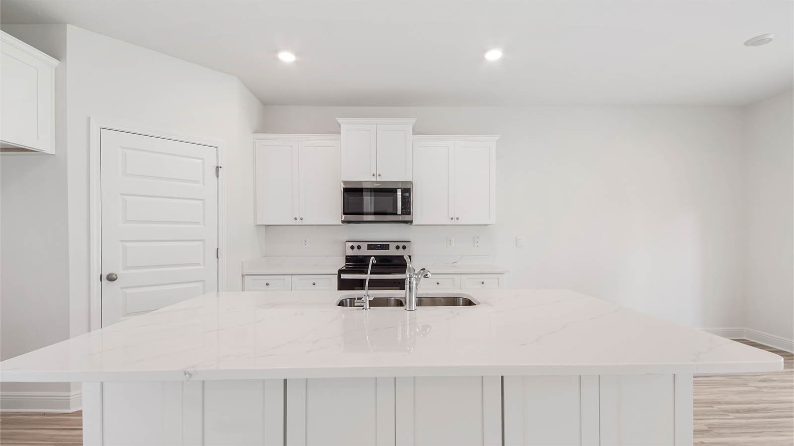 Kitchen island with bar seating and storage cabinets and quartz countertops.