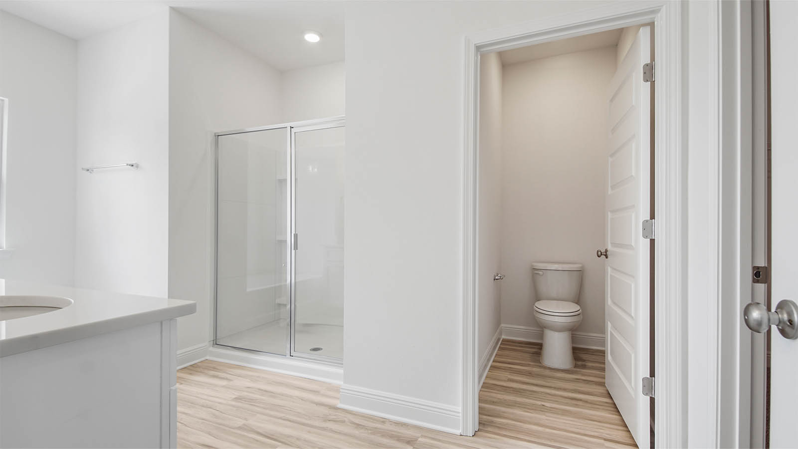 Primary bathroom with EVP flooring and walk-in shower and water closet.