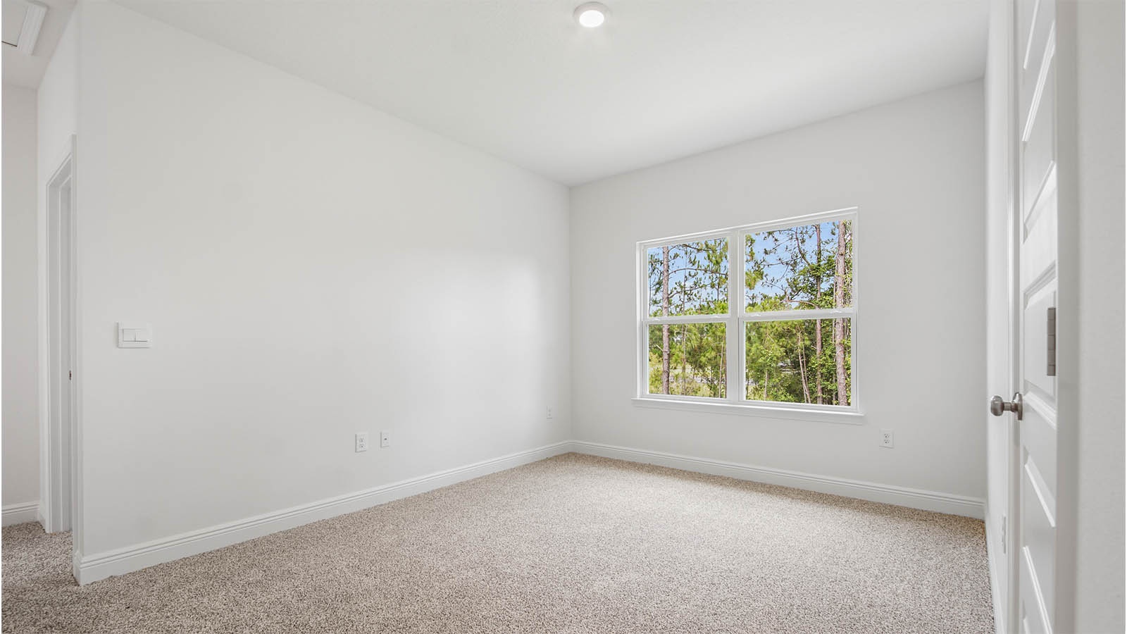 Upstairs bonus area with carpet flooring and large window.
