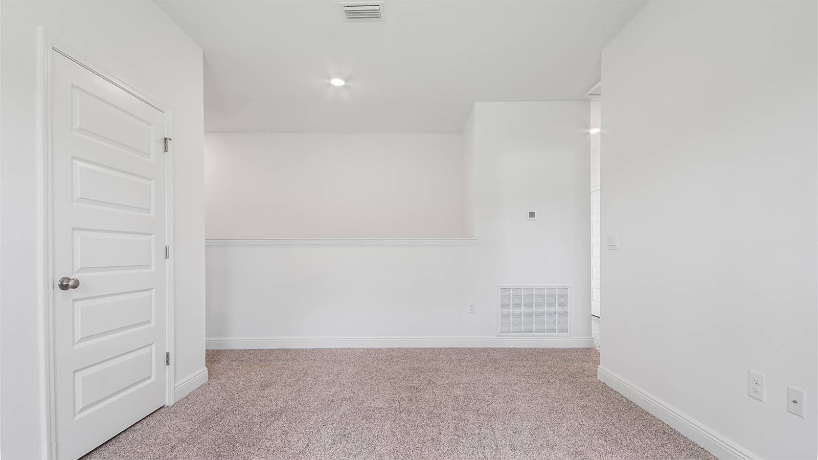 Upstairs bonus area next to hallway with carpet flooring and storage closet.