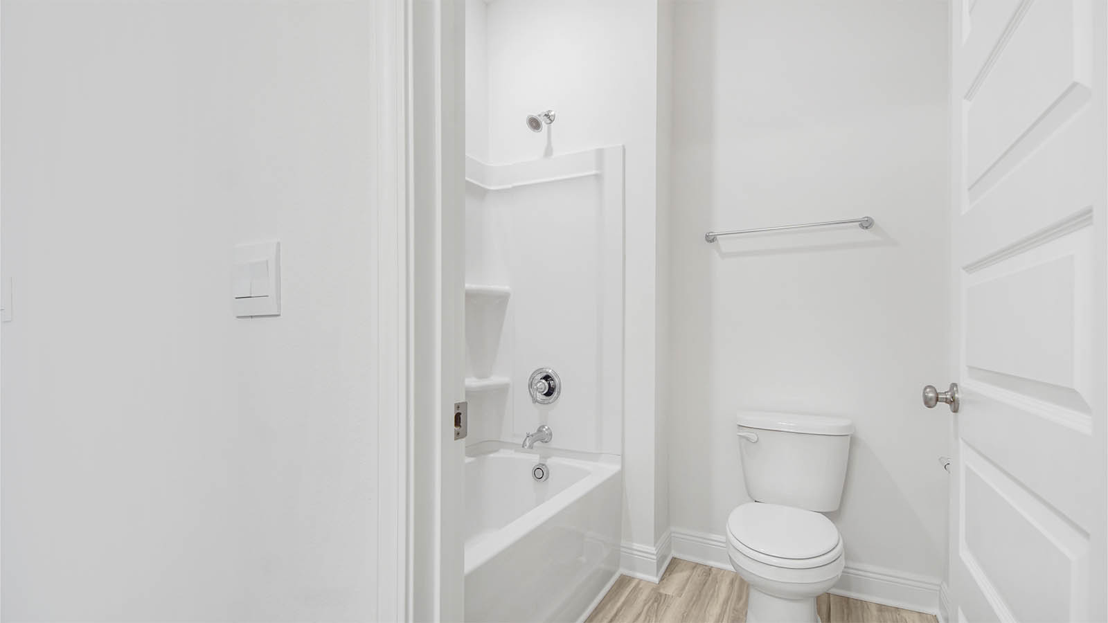 Shower room with tub shower and toilet and EVP flooring.