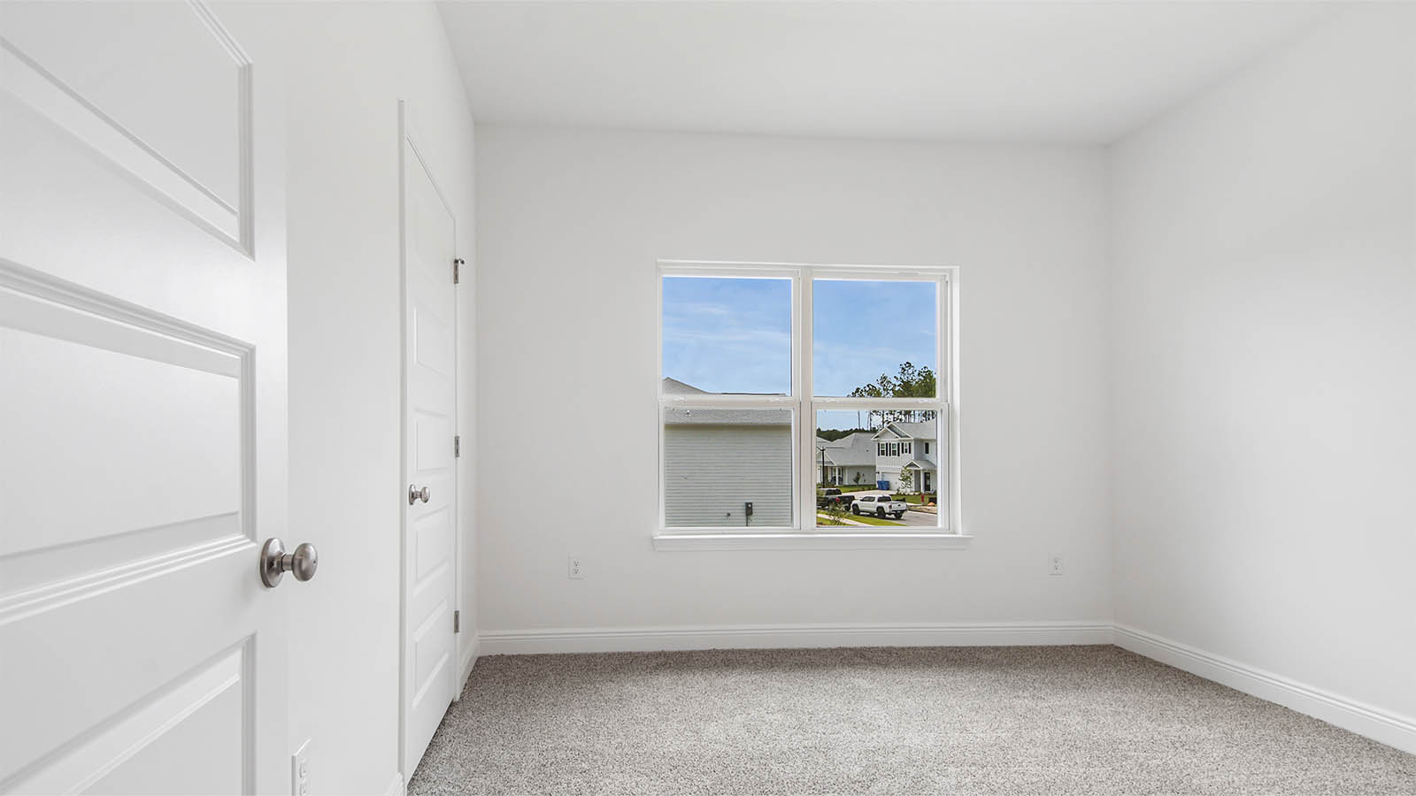 Bedroom five with carpet flooring and large window and closet.
