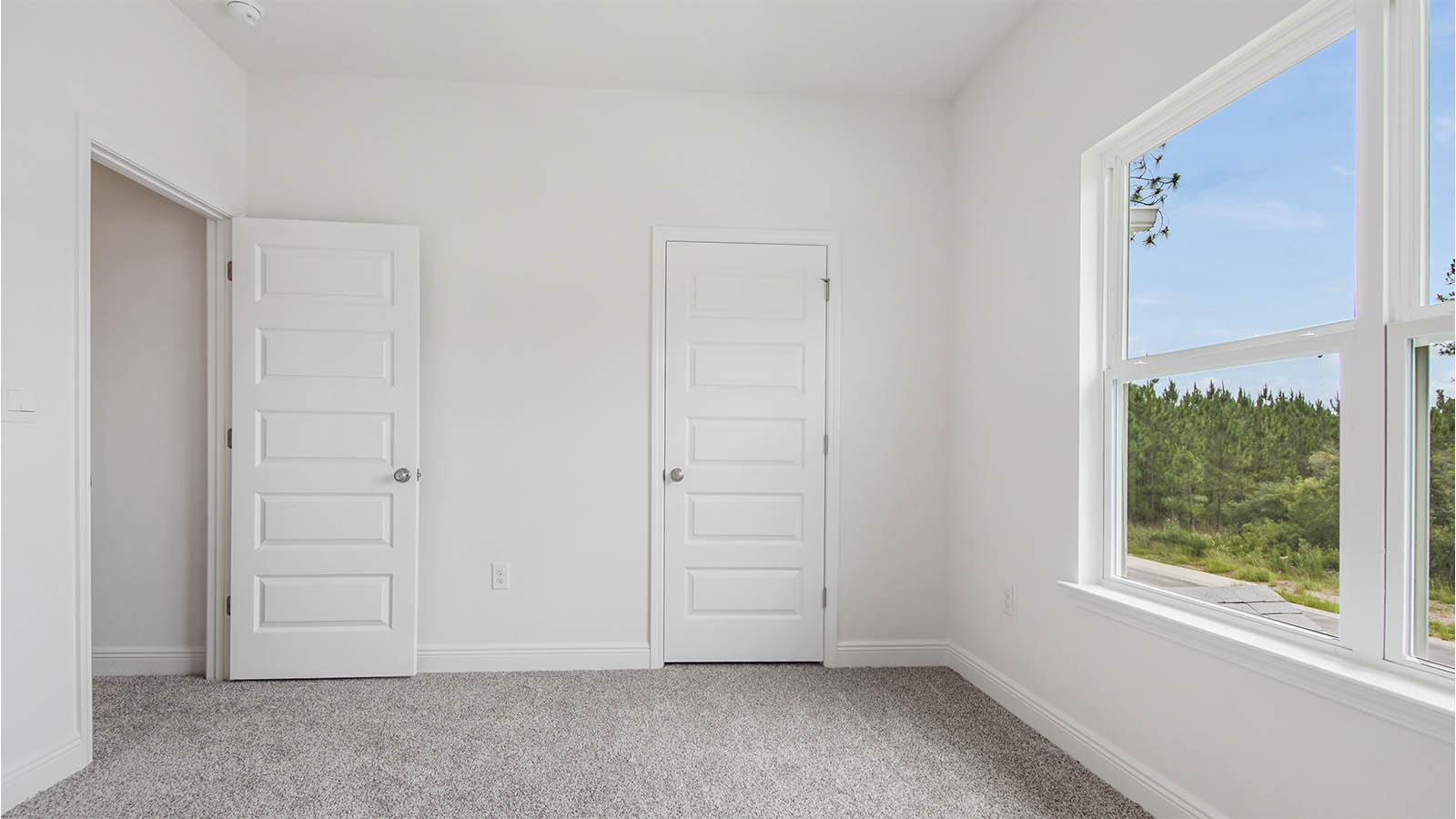 Bedroom five with carpet flooring and large window and closet.