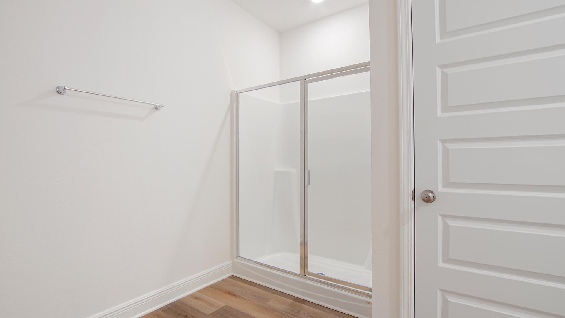 There is a shower with glass enclosure in the primary bathroom