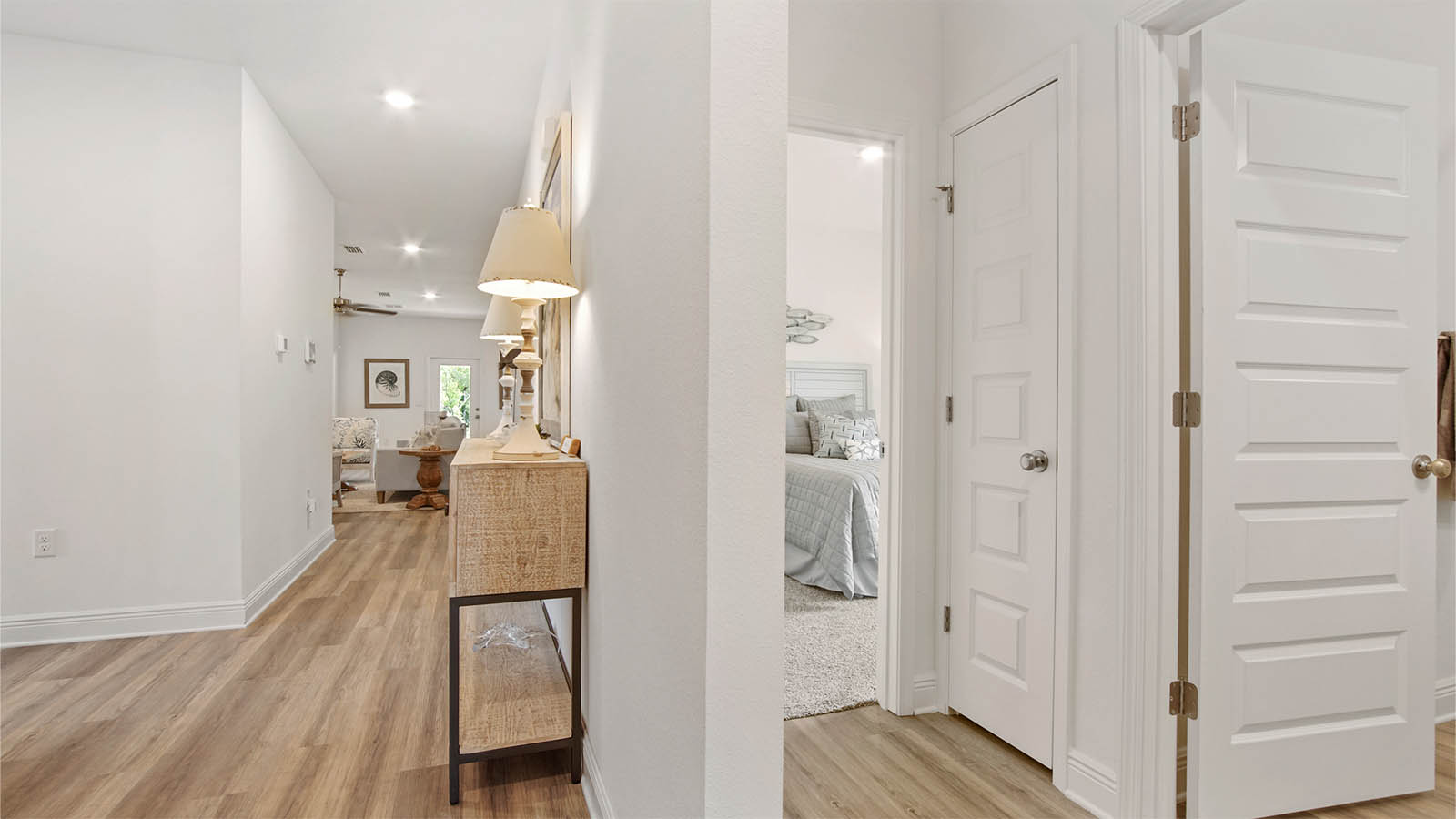 Hallway next to foyer leading to full guest bathroom and bedroom three and linen closet.