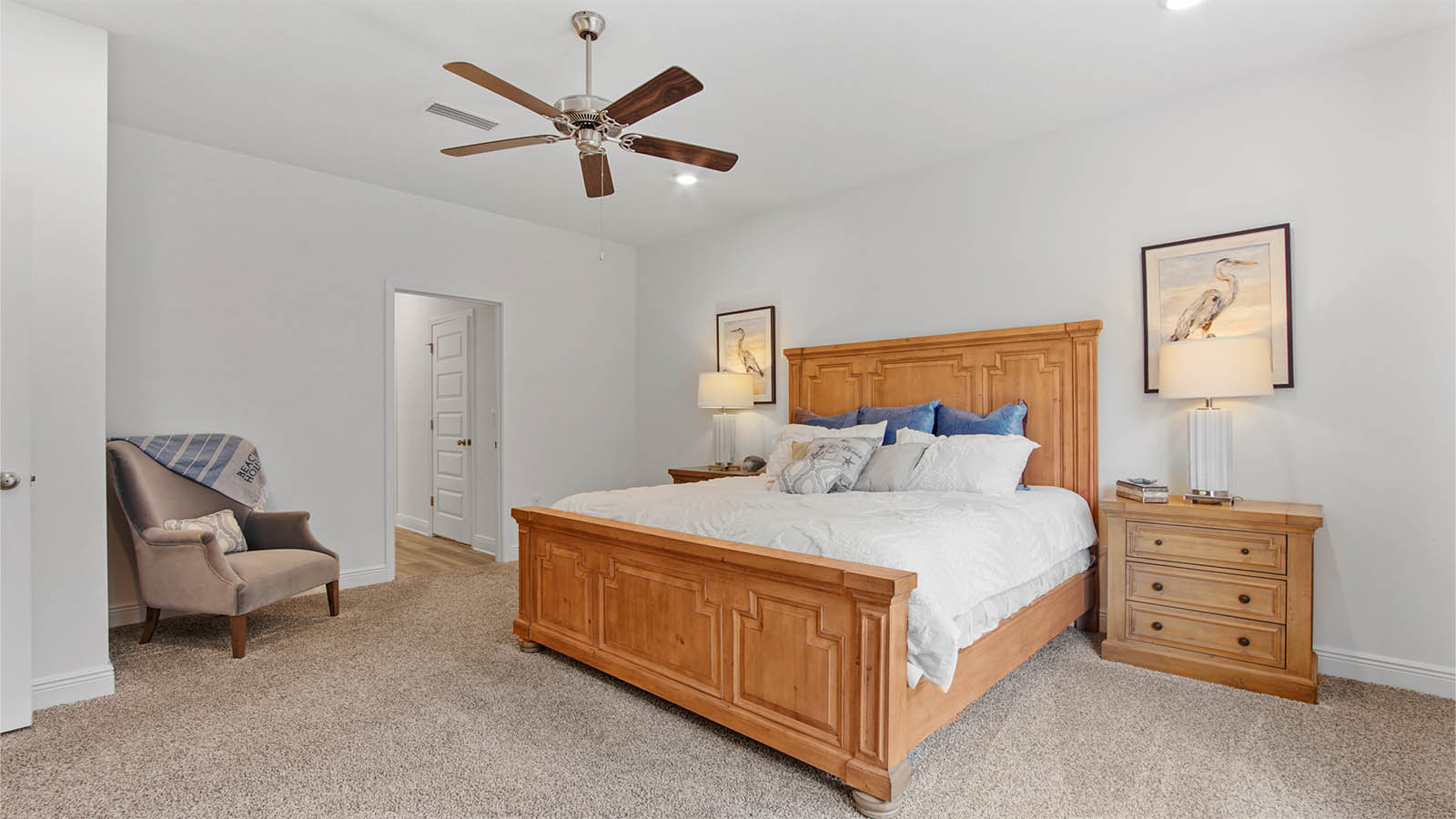 Primary bedroom with ceiling fan and attached full bathroom.