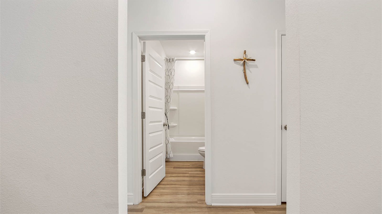 Hallway off foyer to two guest bedrooms and a full bathroom.