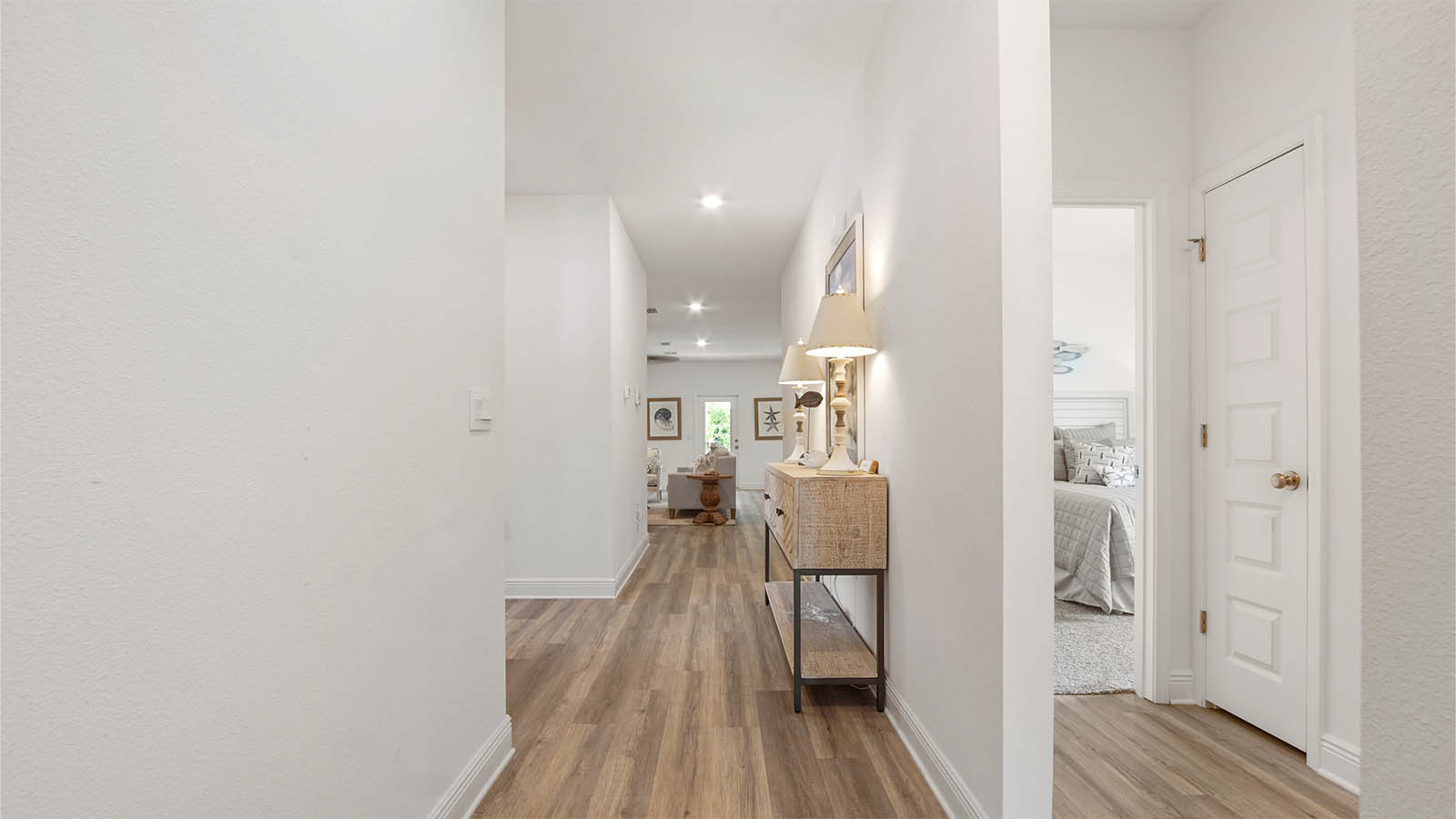 Foyer with EVP flooring and hallway to guest bedrooms and full bathroom and linen closet.
