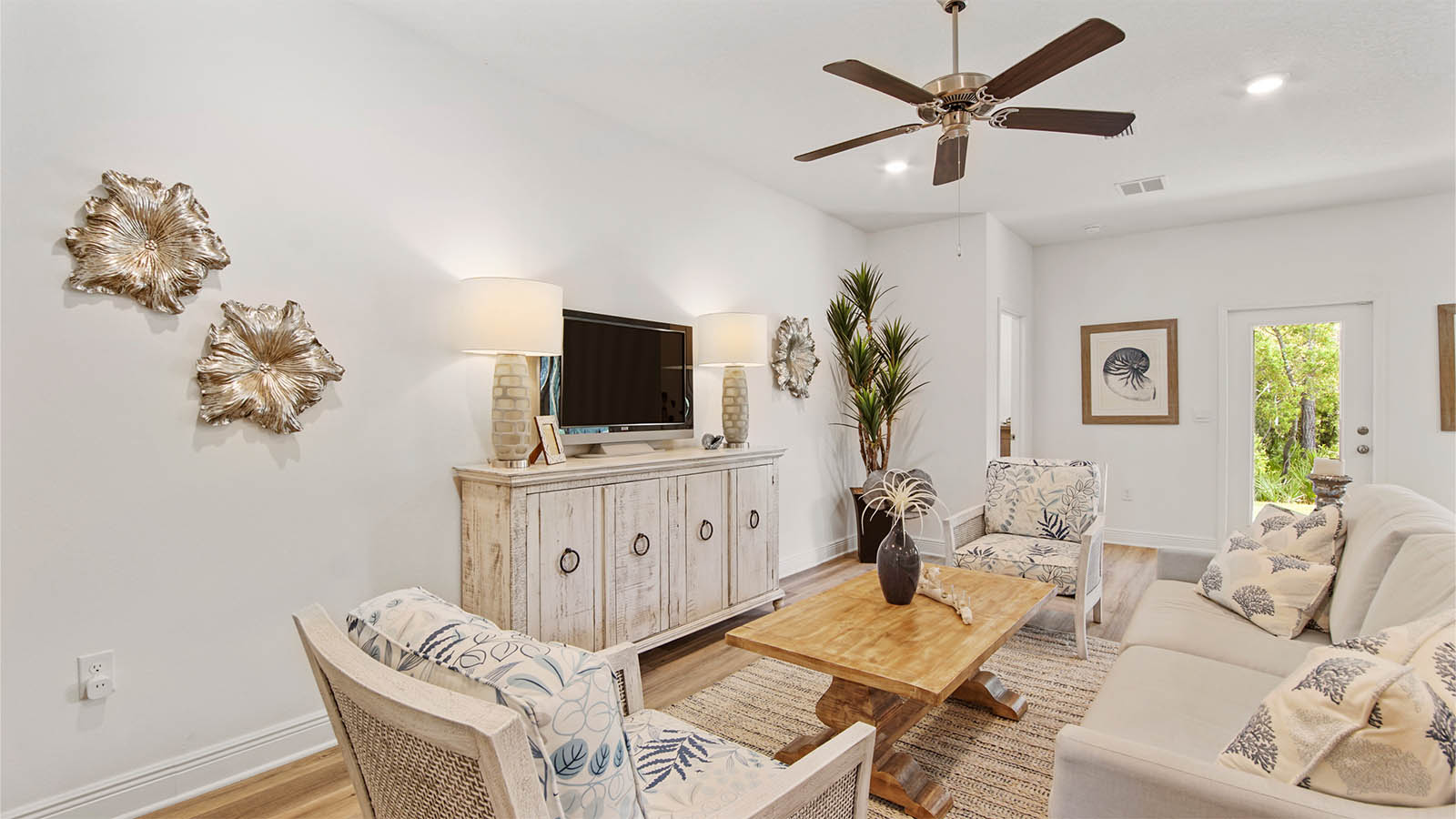 Living area with EVP flooring and ceiling fan and door to primary bedroom next to back door.