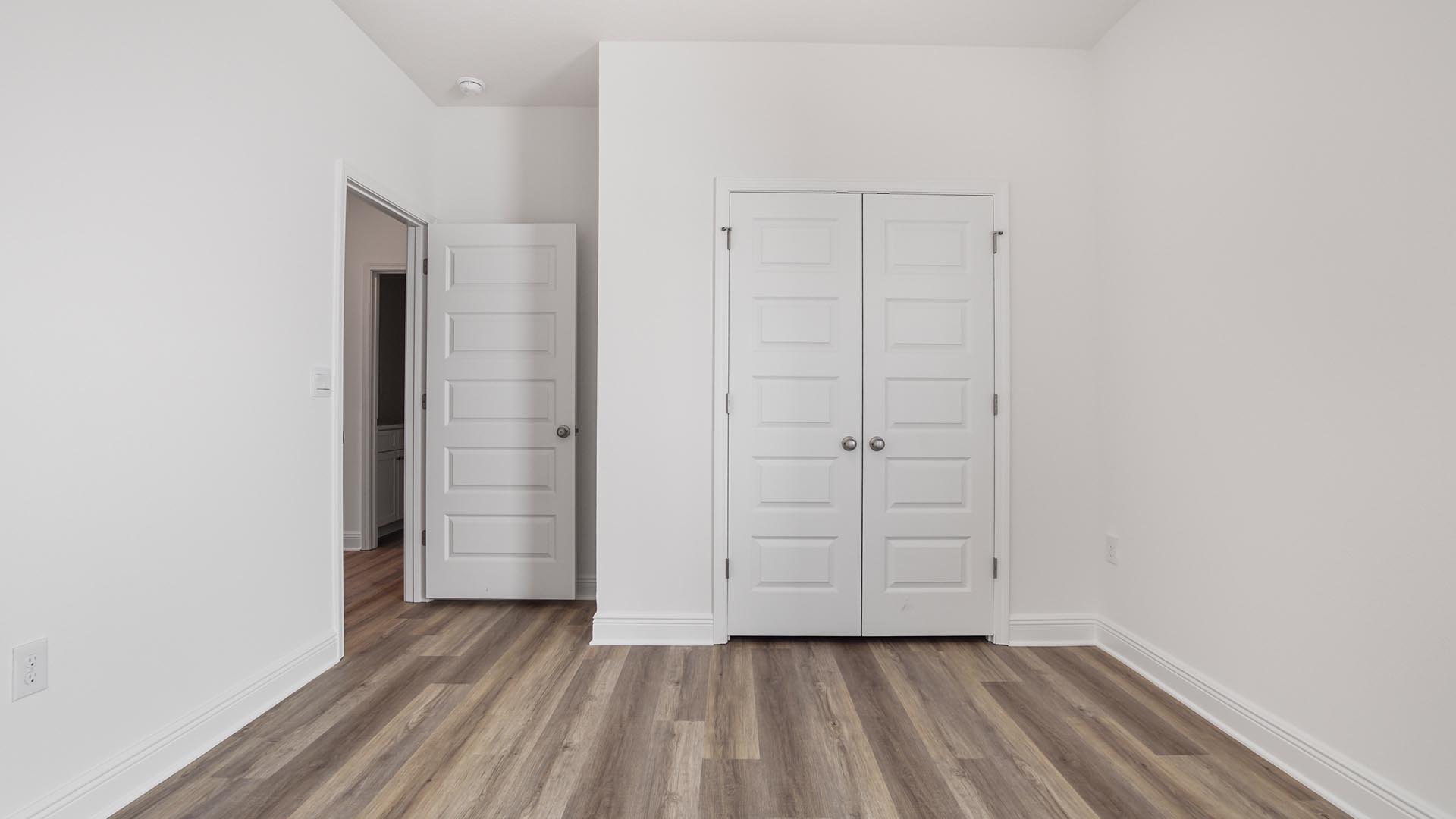 Bedroom two with a double door closet and carpeted flooring.