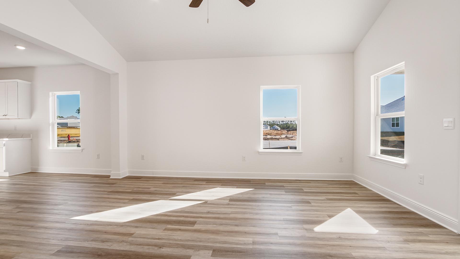 Living room that flows into the kitchen and dining area and vaulted ceilings and EVP flooring.