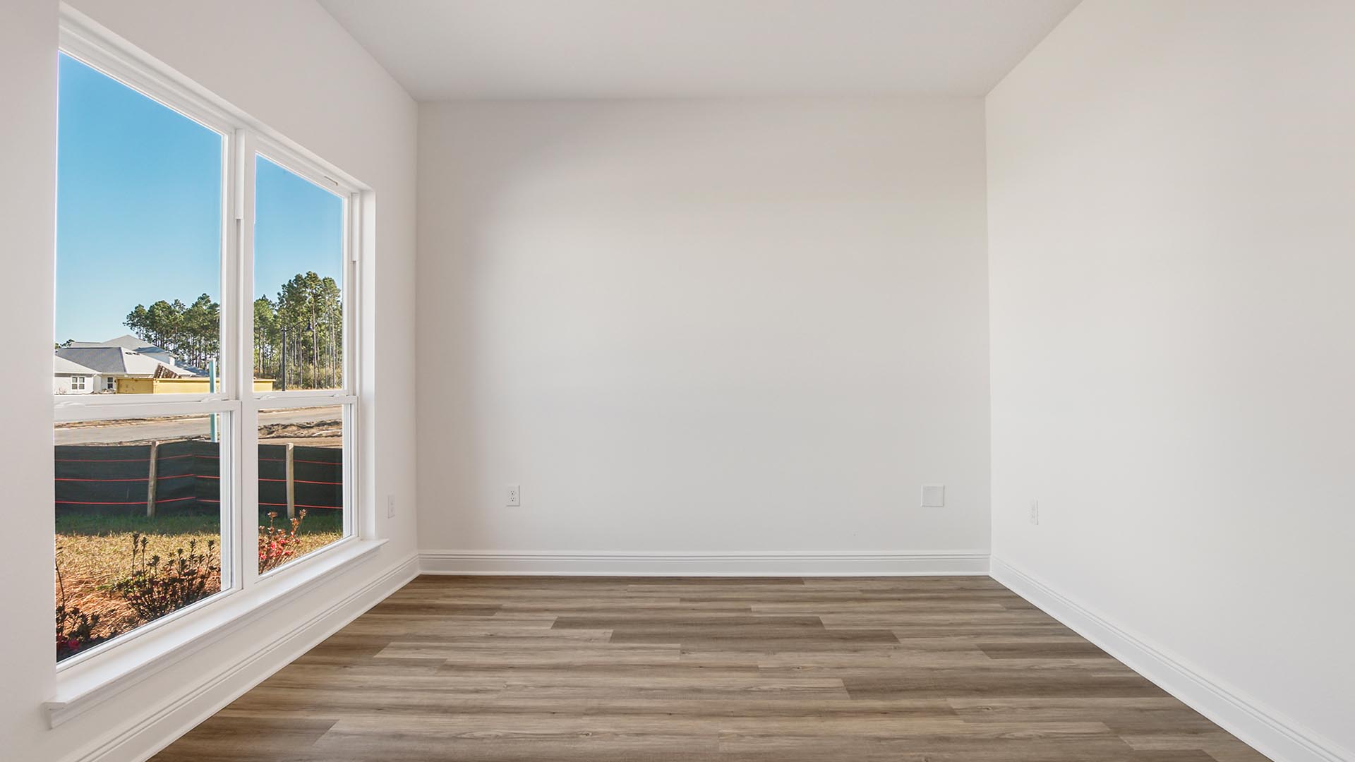 Flex space for an office or formal dining room with EVP flooring and large window.