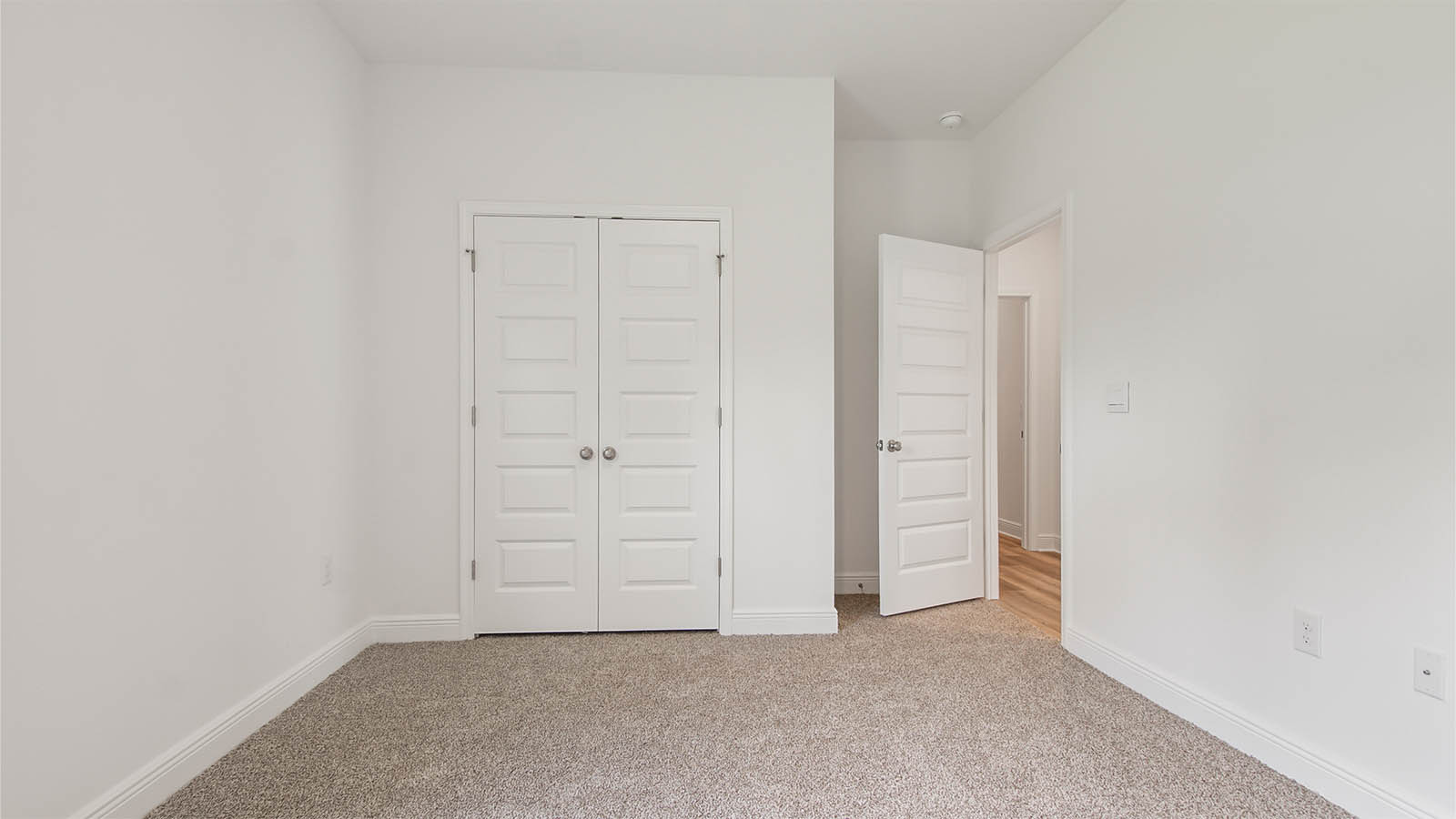 Bedroom two with a double door closet and carpeted flooring.