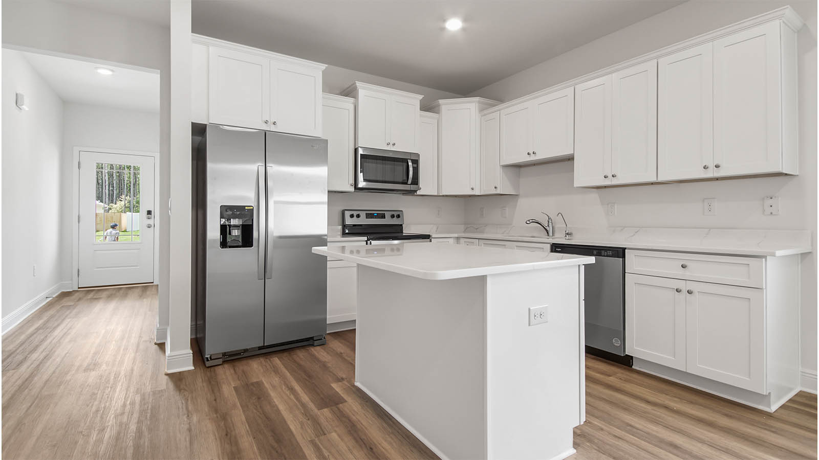 Kitchen with white cabinetry and quartz countertops and stainless steel appliances.