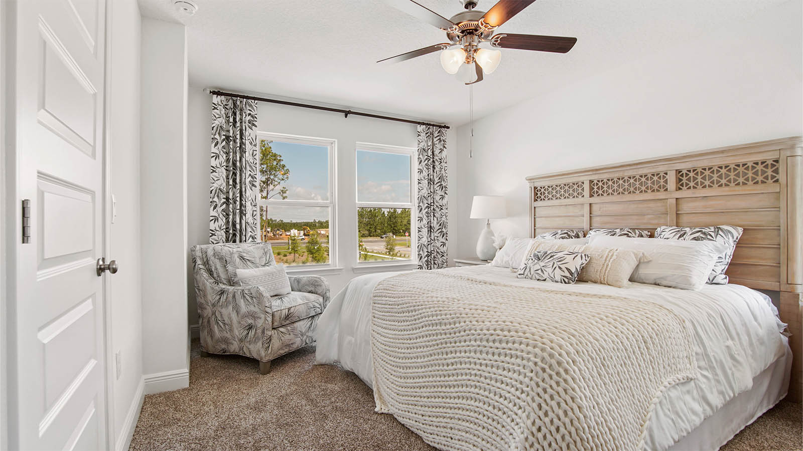 Primary bedroom features multiple windows for natural lighting