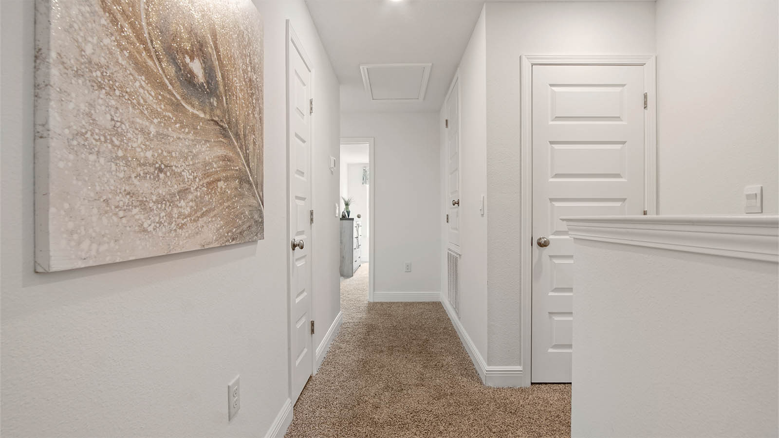 Hallway leading from primary bedroom to additional bedrooms