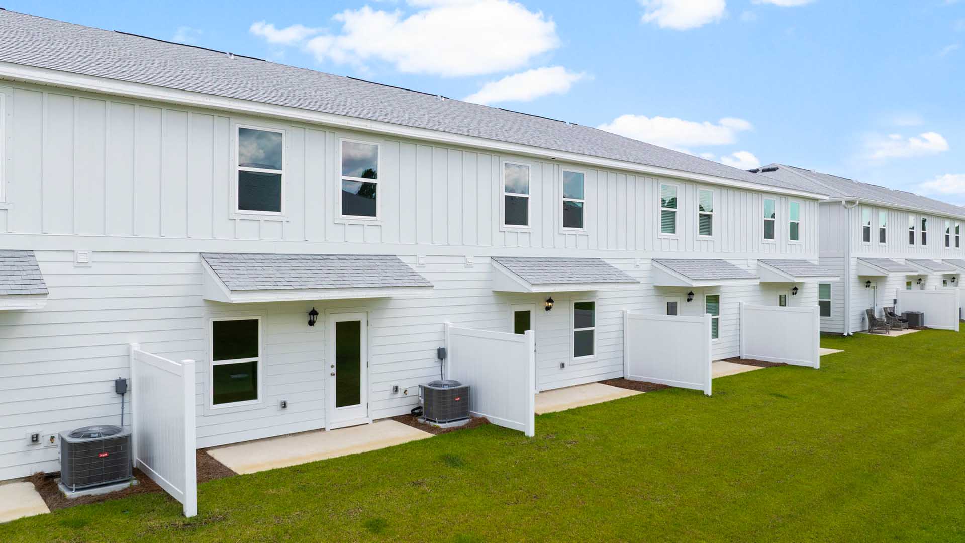 The back of the townhome has a patio and a partition between units