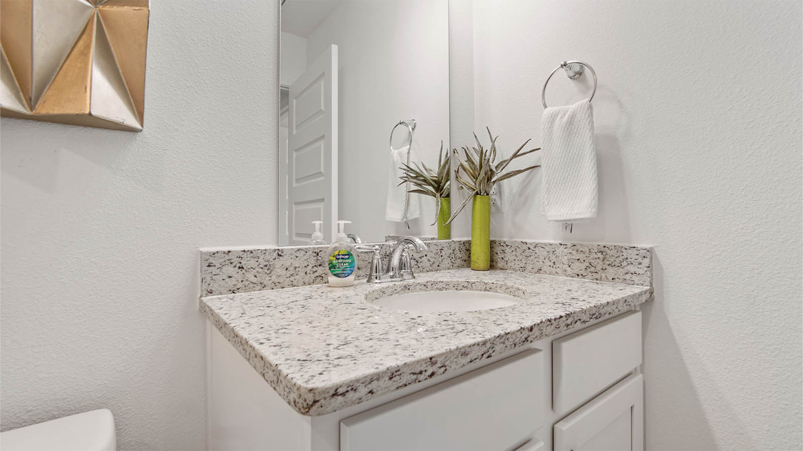 Shared bathroom with single vanity featuring quartz countertops