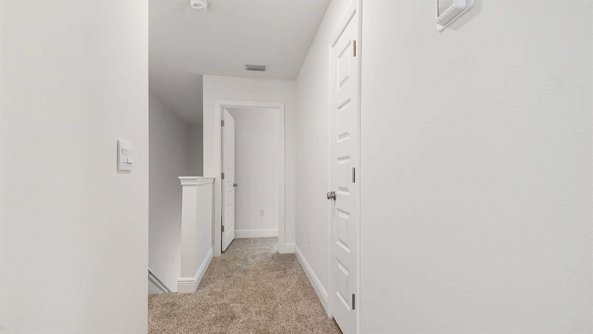 Second level landing and hallway with carpet