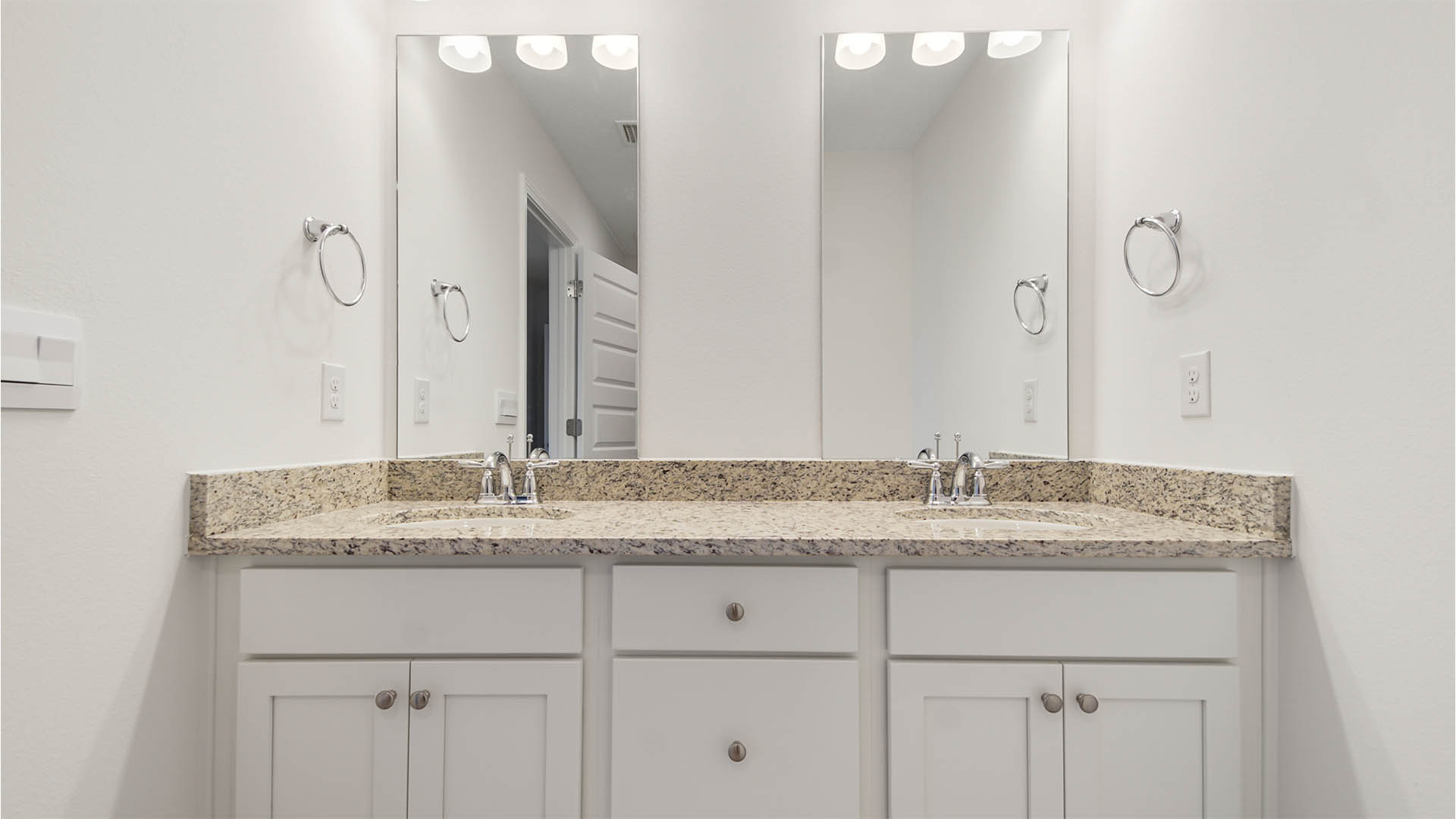 Primary bathroom with beautiful white cabinetry and granite countertops