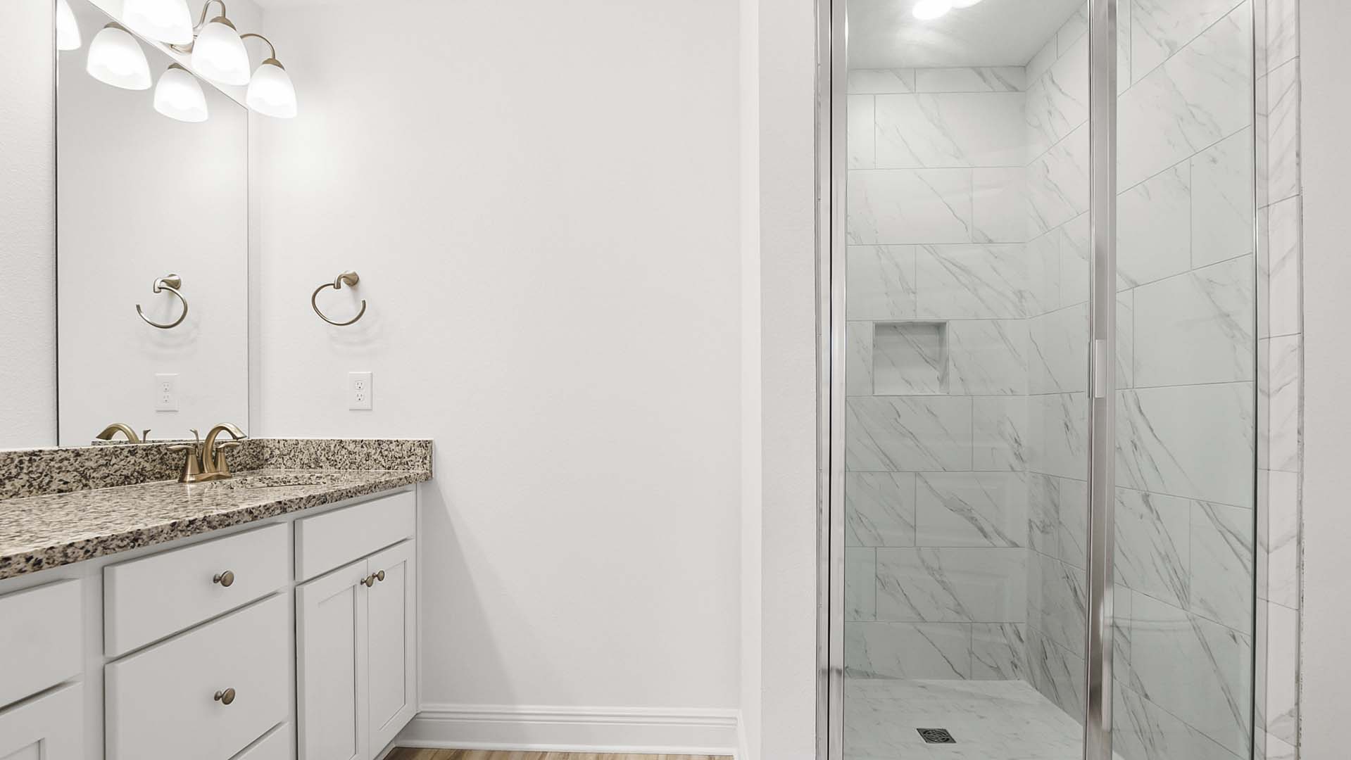 The primary bath has a dual sink vanity with lower cabinetry and drawers for storage