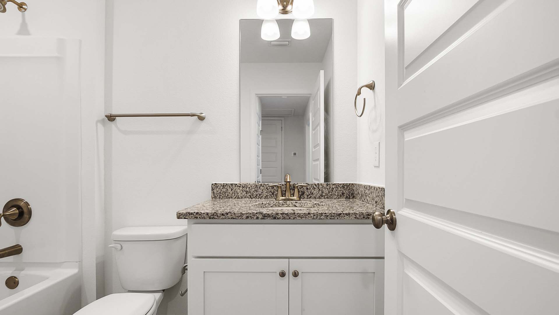The shared bath has a single vanity with lower cabinetry for storage