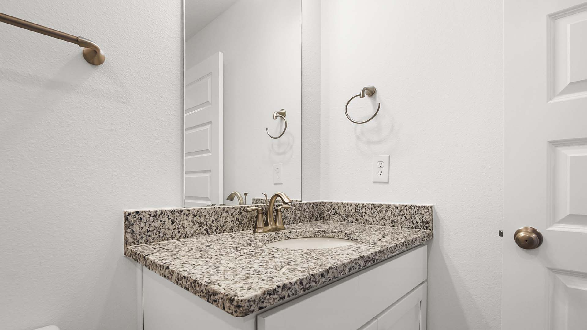 The single vanity in the shared bath has granite countertops