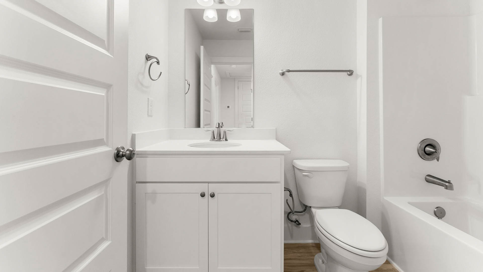 There is a shared bathroom that has a shower tub combination and a single vanity with lower cabinetry and quartz countertops