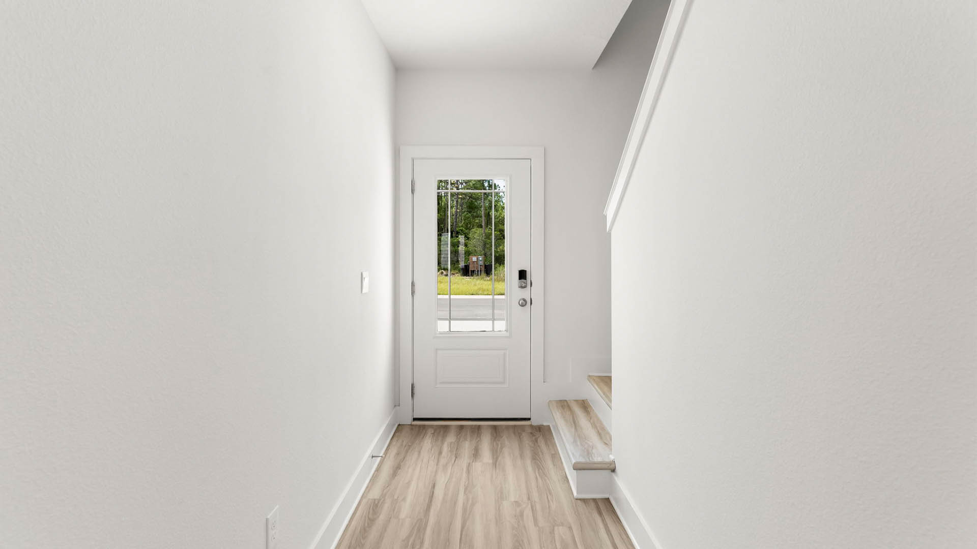 The entry door has a glass window allowing for natural light to flood the foyer