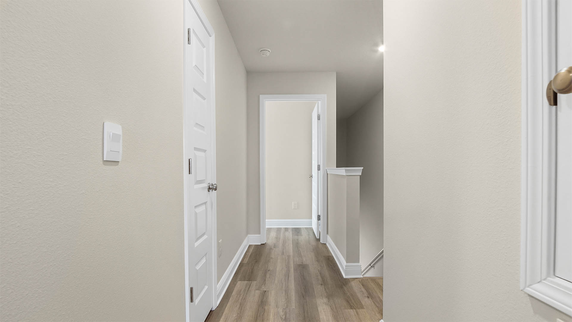 Upstairs foyer with EVP flooring and primary bedroom entrance.