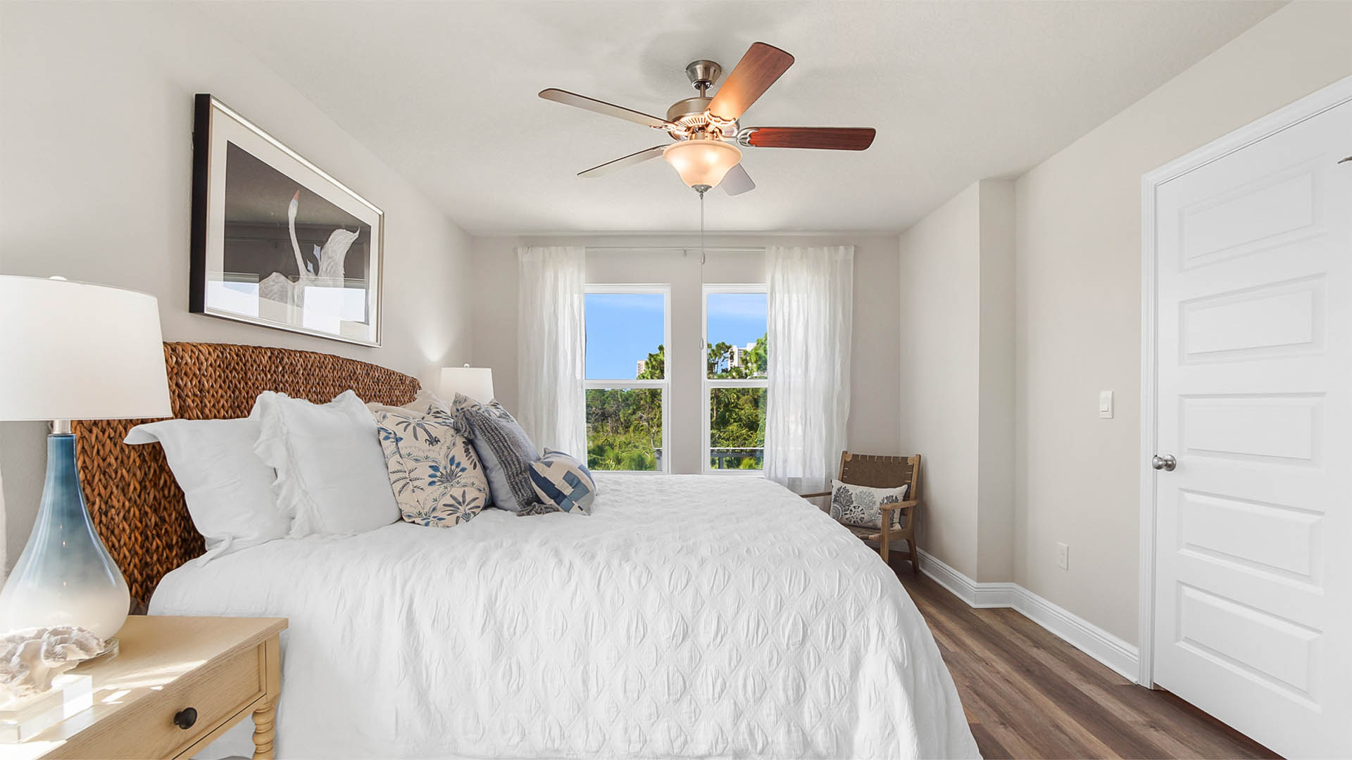 Primary bedroom with EVP flooring and large windows and large walk in closet.