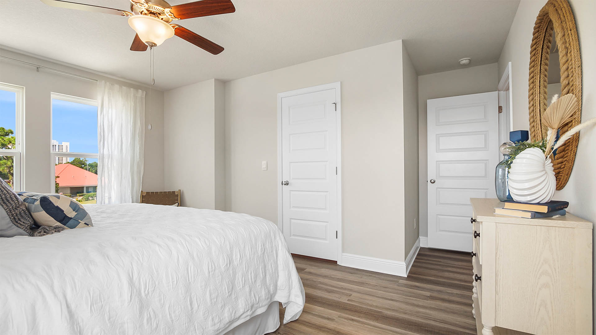 Primary bedroom with EVP flooring and windows and large walk-in closet.