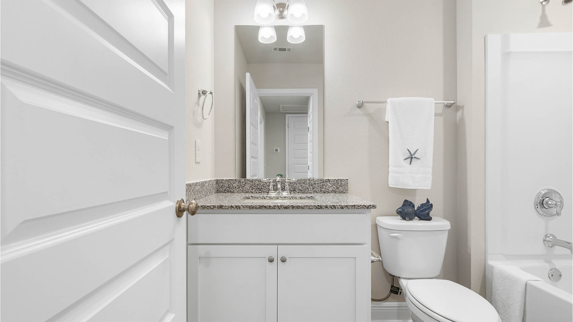 Bathroom with single vanity with granite countertops and shower tub combination and toilet.