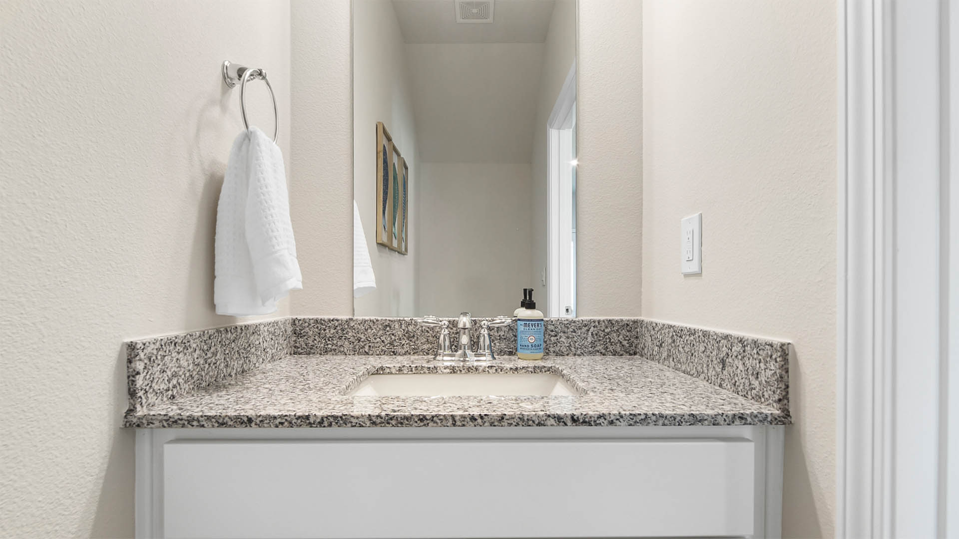 Half bathroom with granite countertops and single sink vanity.