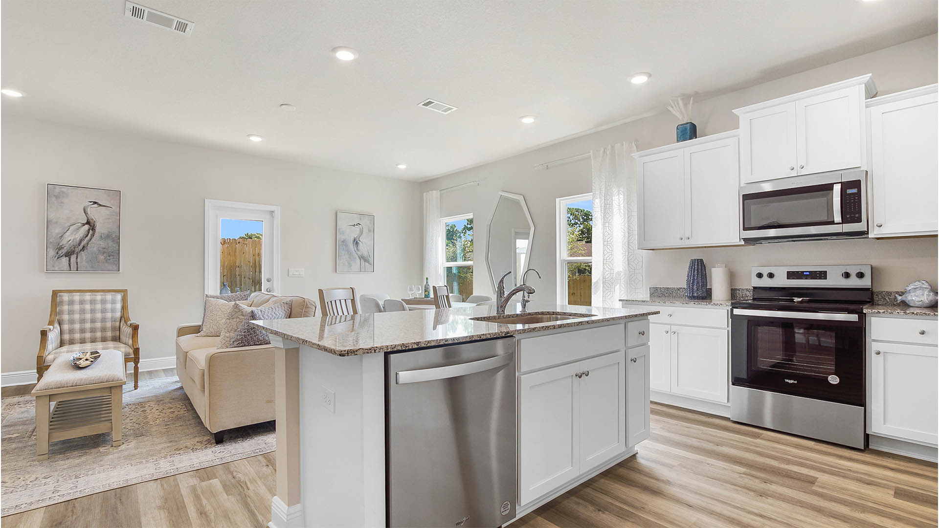 Open kitchen and dining room with EVP flooring and white cabinetry and large kitchen island.