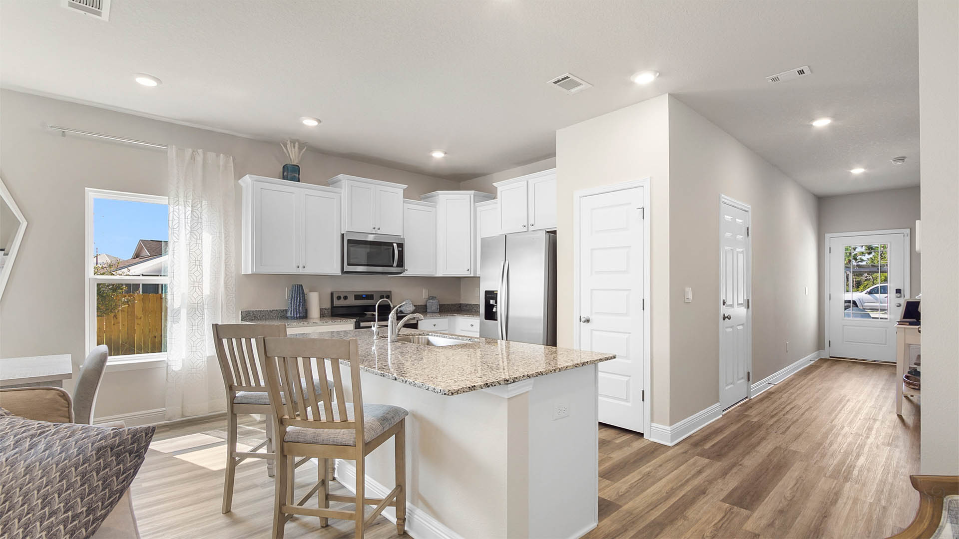 Open kitchen with island bar seating and granite countertops.
