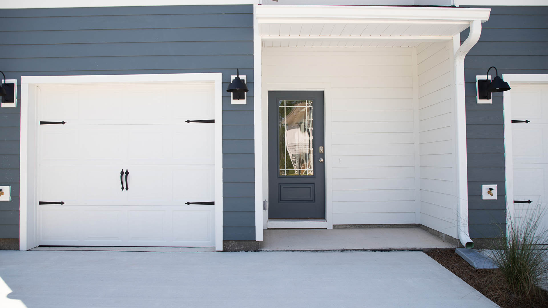 Townhome front door with covered patio and next to garage.