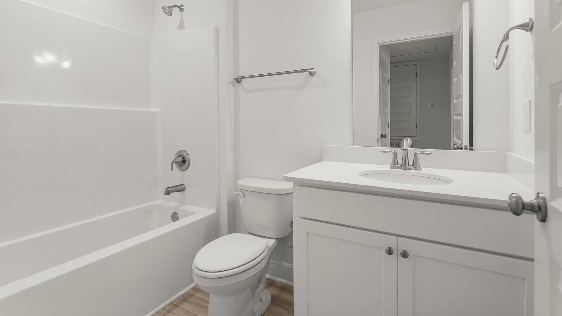 The shared bathroom has a shower and tub combination and a single vanity with quartz countertops