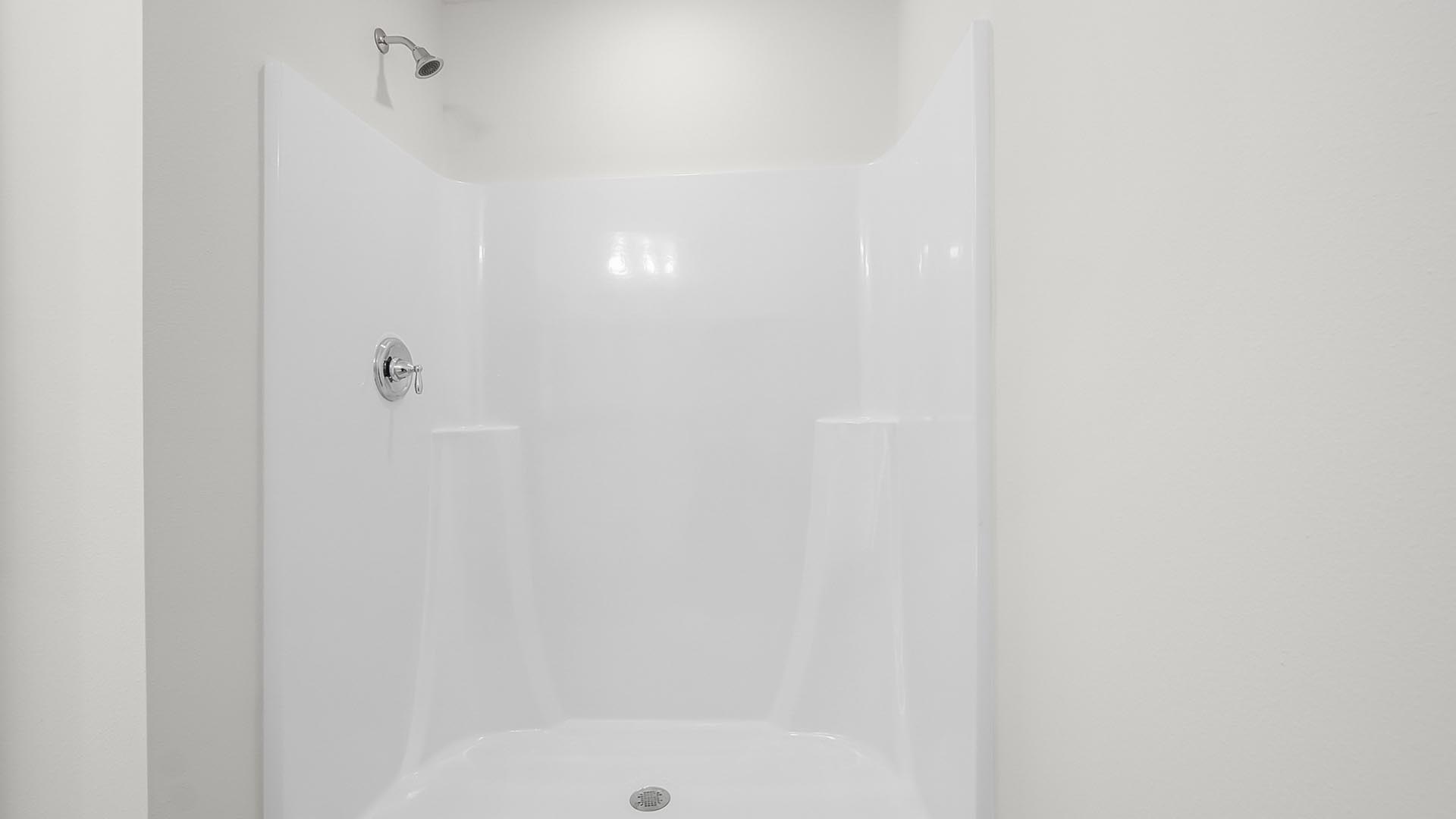 The bathroom bath has a large shower