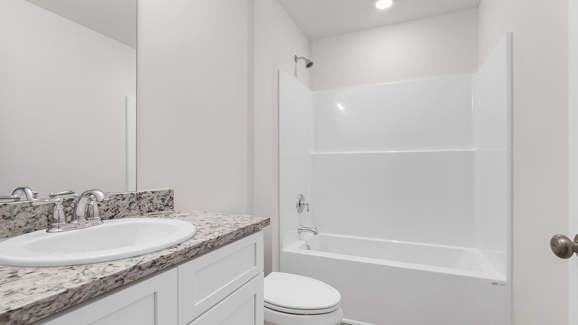 The shared bathroom has a single vanity with granite countertop and lower cabinetry