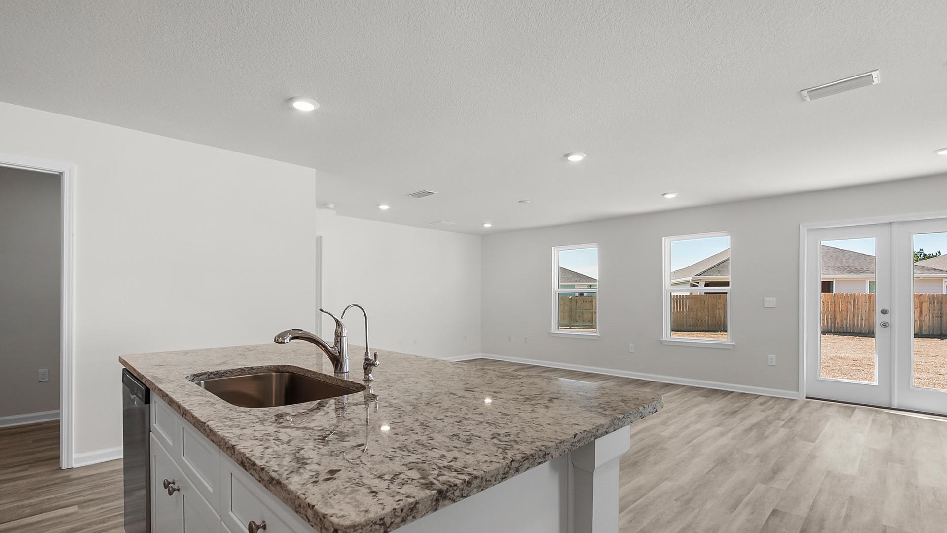 The kitchen has a center island with granite countertop as well as a sink and dishwasher