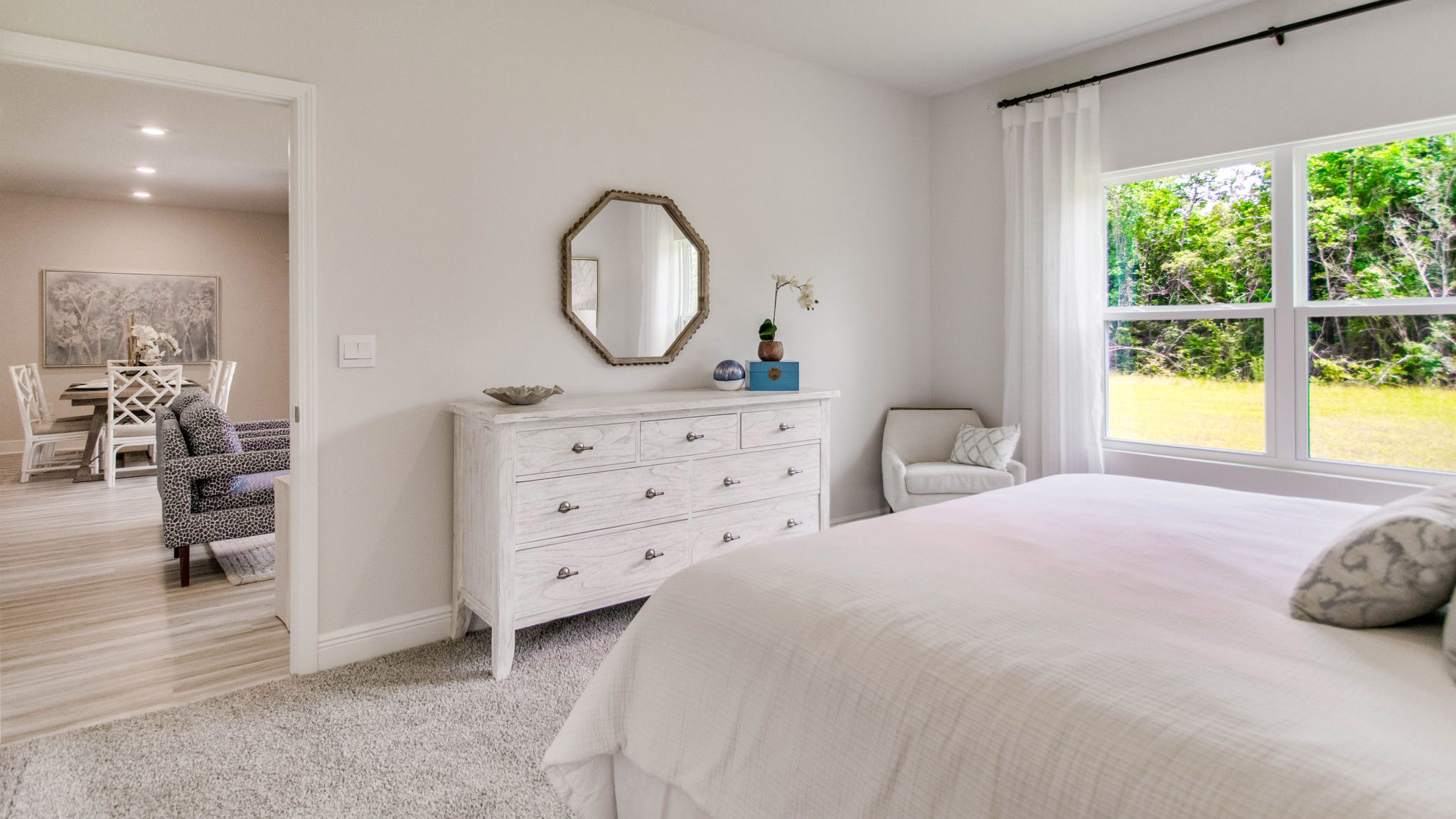 The primary bedroom has a large picture window allowing for natural light