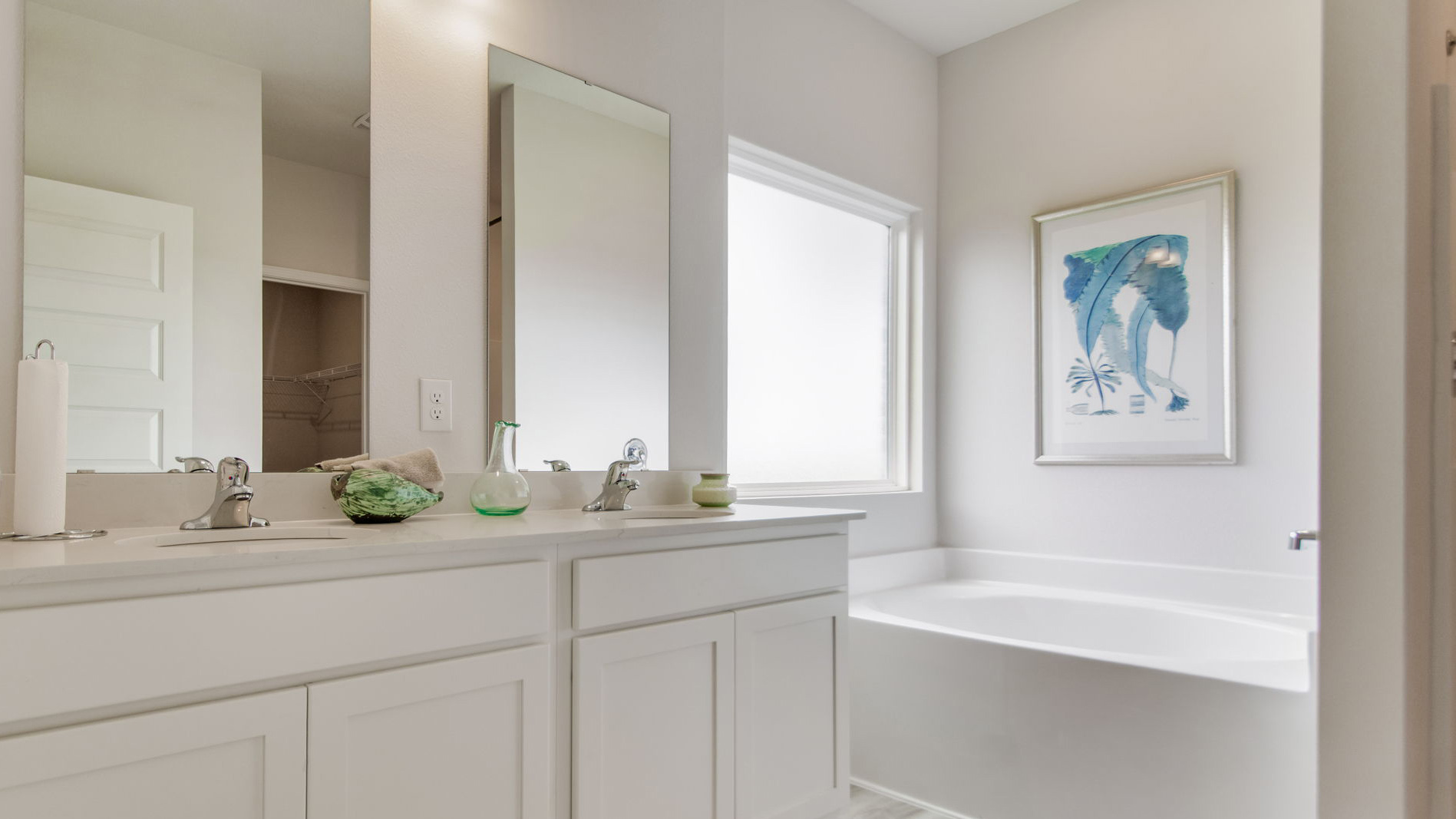 The primary bathroom has a dual sink vanity and lower cabinetry for storage