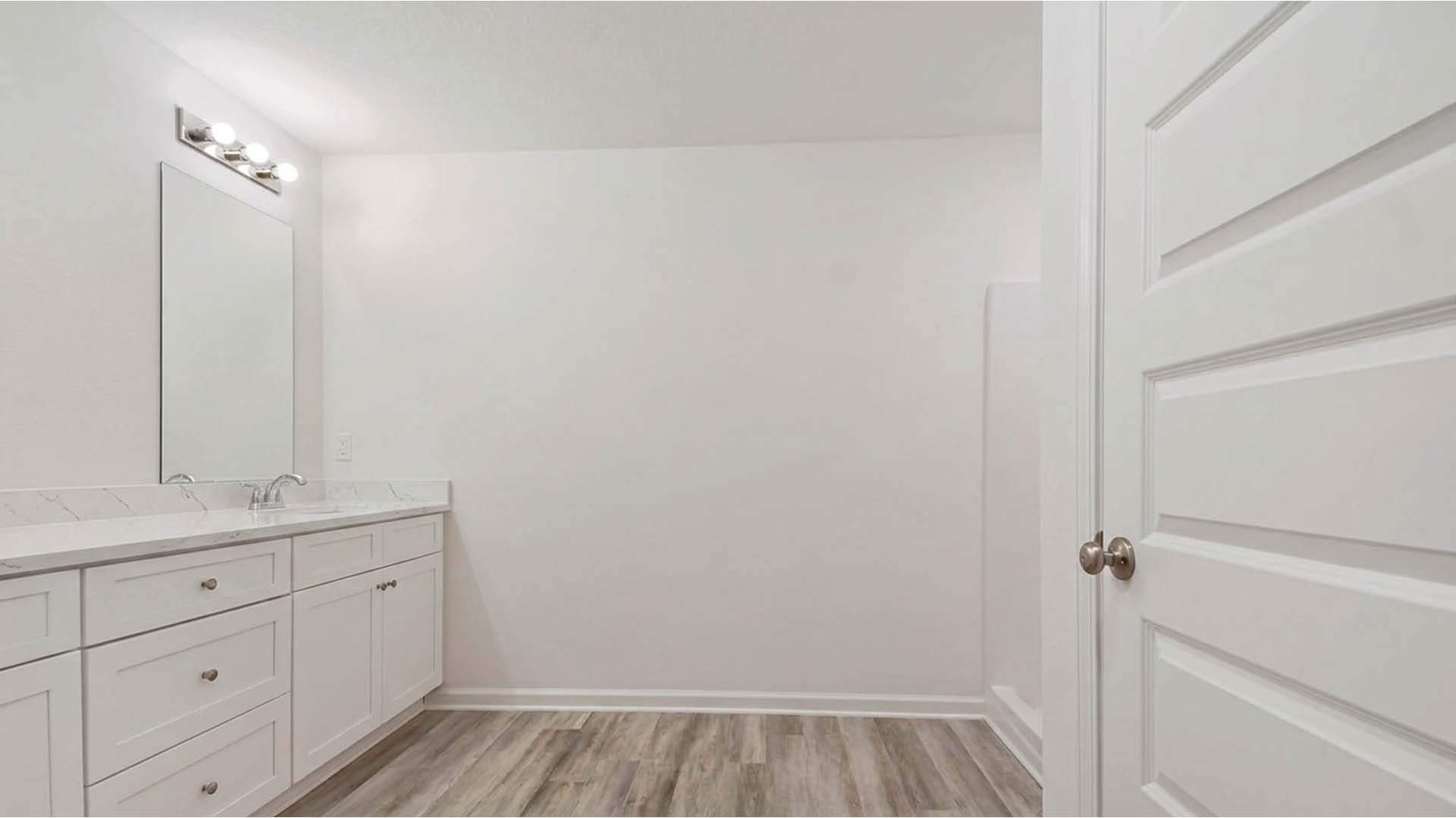 Primary bathroom has a vanity with quartz countertops and dual sinks