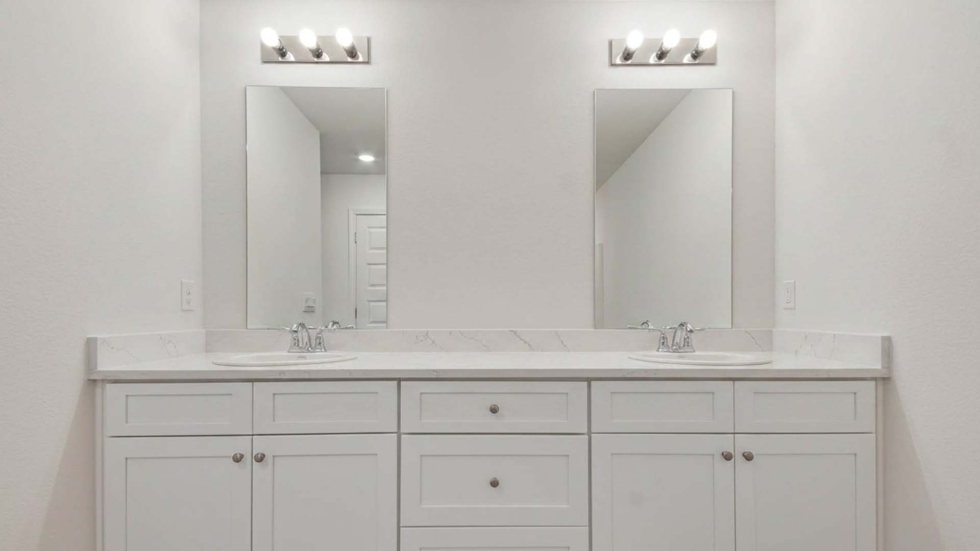 Primary bath with dual sink vanity and lower cabinetry and quartz countertop