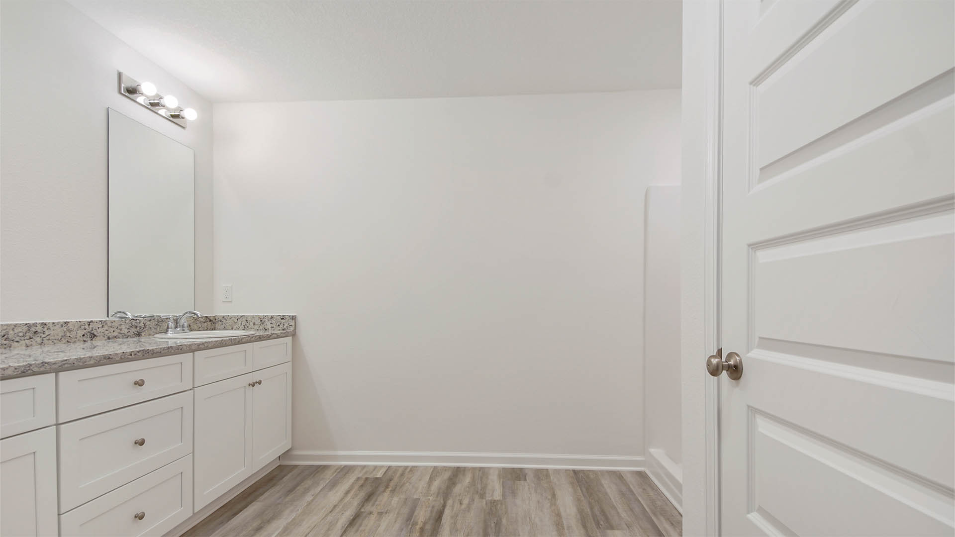 Primary bathroom has a vanity with quartz countertops and dual sinks