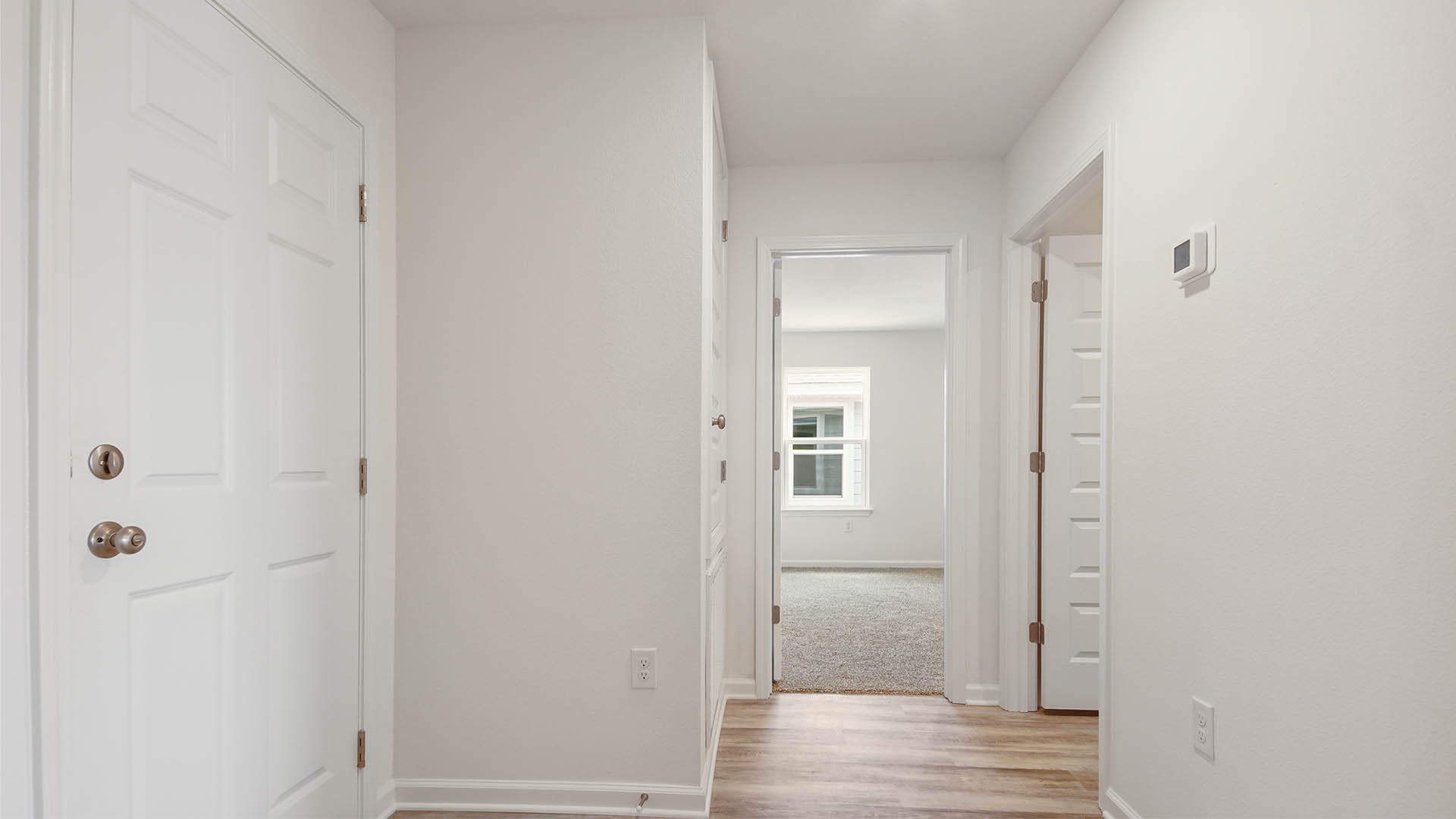 Hallway leading to bedroom four and the laundry room and garage